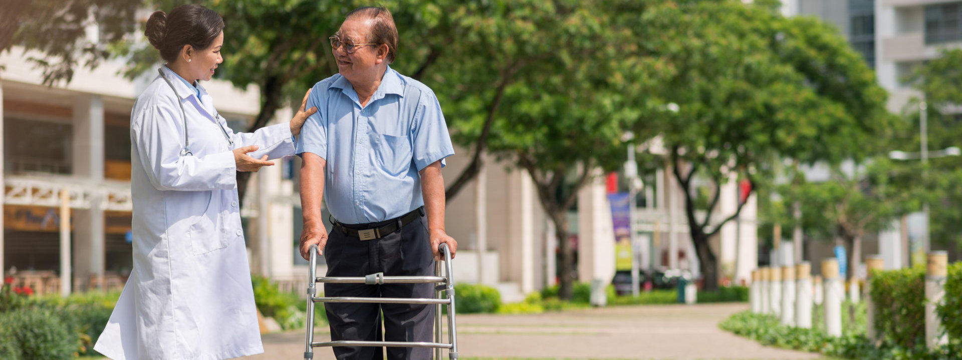 Senior man moving with walker with help of doctor