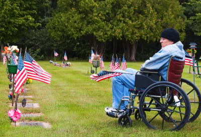 Disabled veteran in a wheelchair at the cemetery remembering his fallen brothers